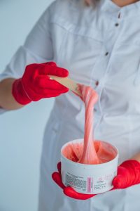 Crop woman with jar of sugaring paste